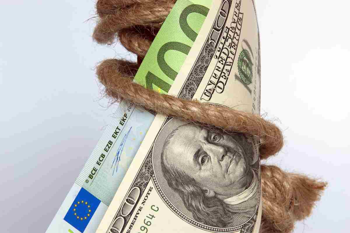 Banconote di euro e dollari strette da una corda